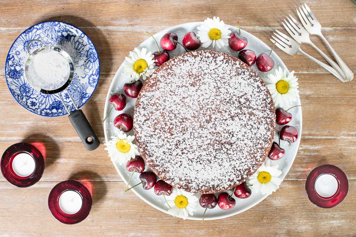 Horizontal overhead photo of a Ridiculously Easy Sweet Cherry Almond Cake on a dining table.