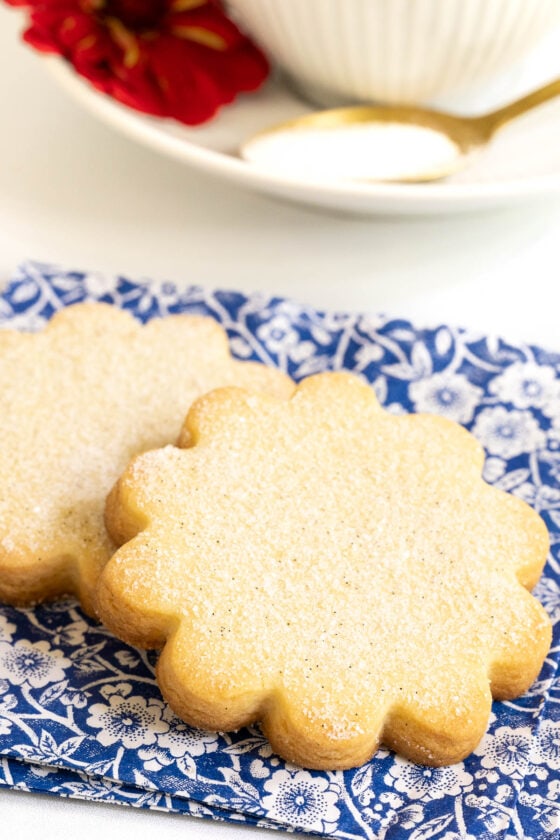Vertical closeup photo of two French Shortbread Cookies on a blue and white patterned napkin.