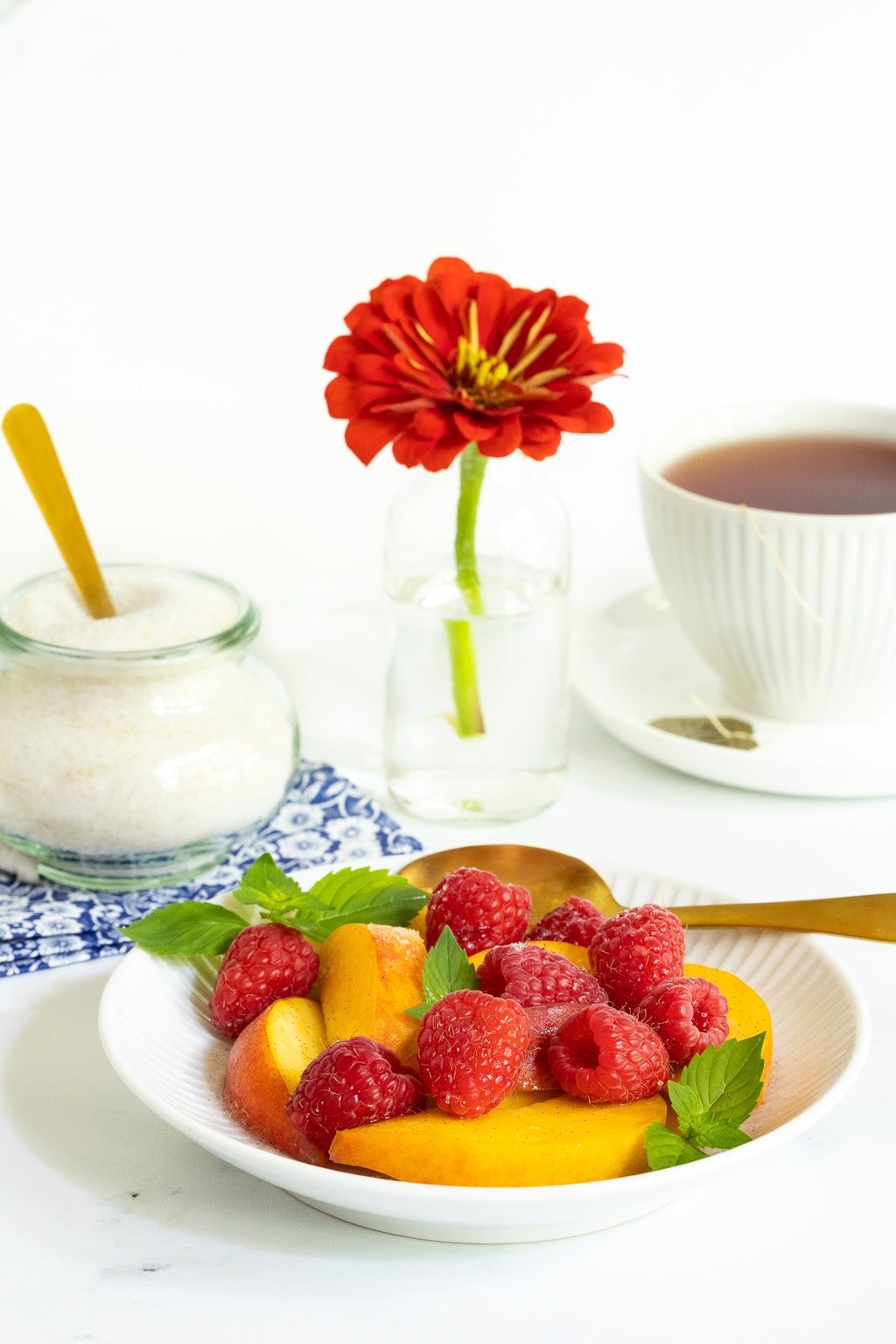 Vertical photo of a bowl of fresh fruit sprinkled with French Vanilla Sugar (Sucre Vanillé).