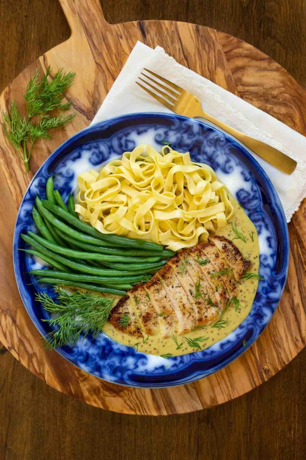Vertical overhead photo of French Mustard Chicken Breasts (Poulet à la Moutarde Française) with French green beans and fresh pasta on a Flo Blue plate.