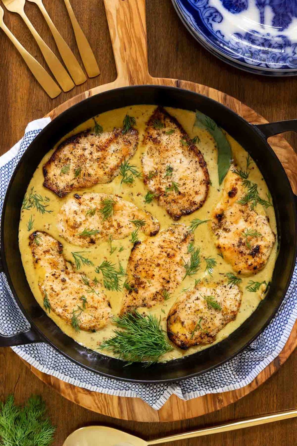 Vertical overhead photo of a skillet of French Mustard Chicken Breasts (Poulet à la Moutarde Française) on a wood table.