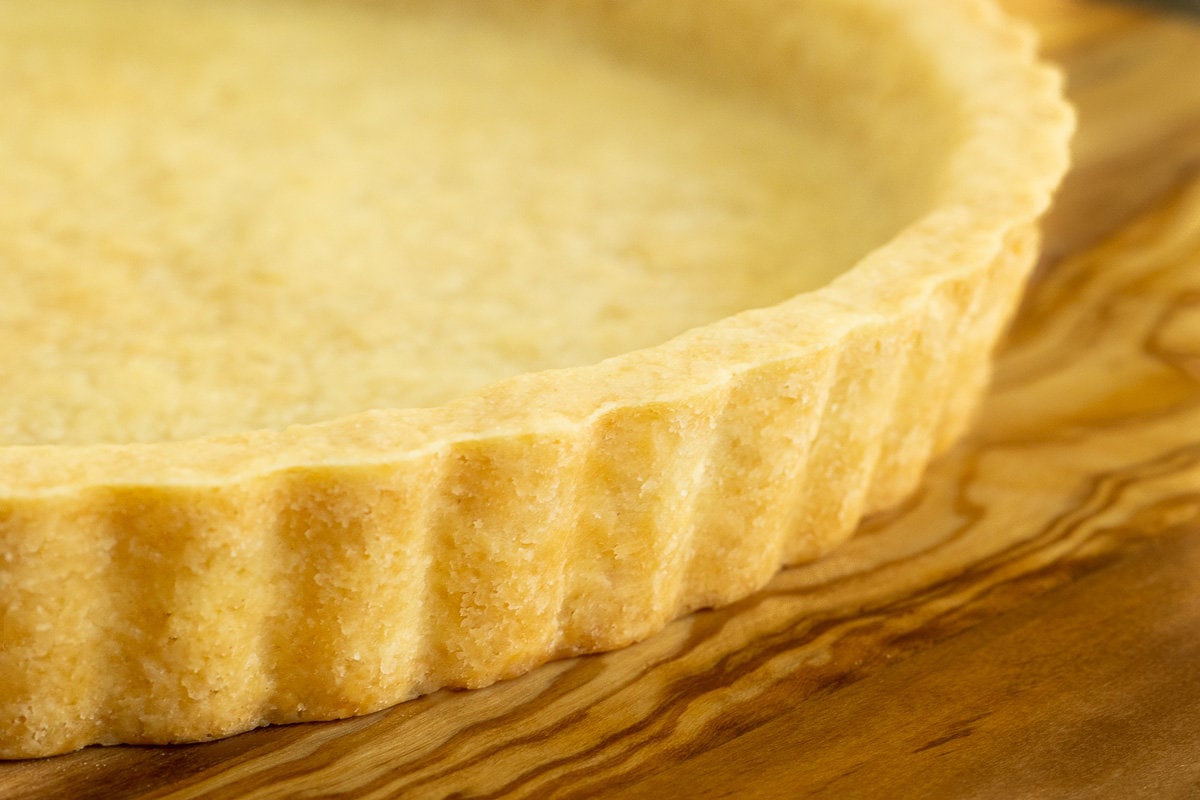 Horizontal extreme closeup of a Ridiculously Easy Easy Press-In Tart Crust on a wood surface.