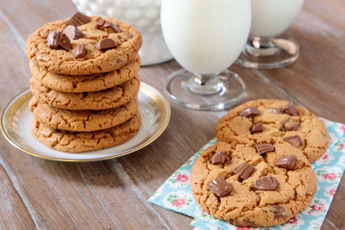 Horizontal photo of a batch of One Bowl Reese's Peanut Butter Cup Cookies on a serving plate and napkin.