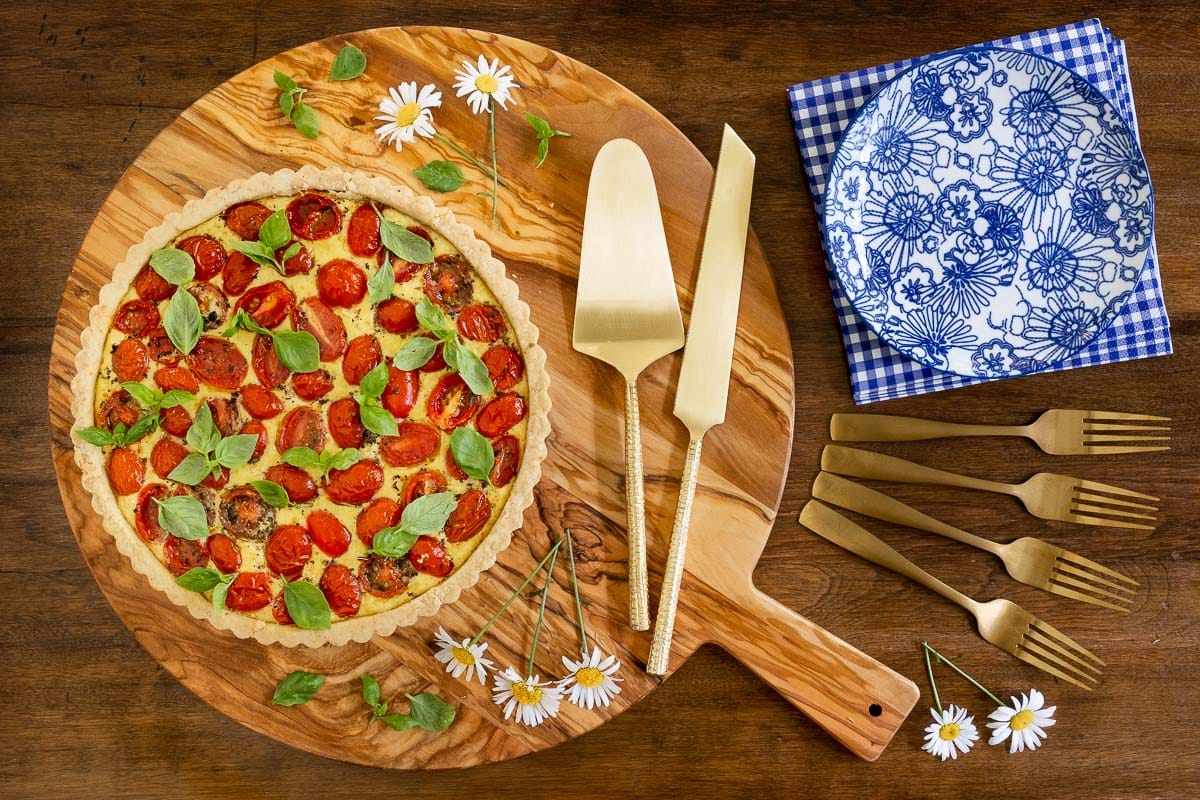 Horizontal overhead photo of a savory tart using the Ridiculously Easy Press-In Tart Crust (for Sweet or Savory Tarts) on a wood cutting board.