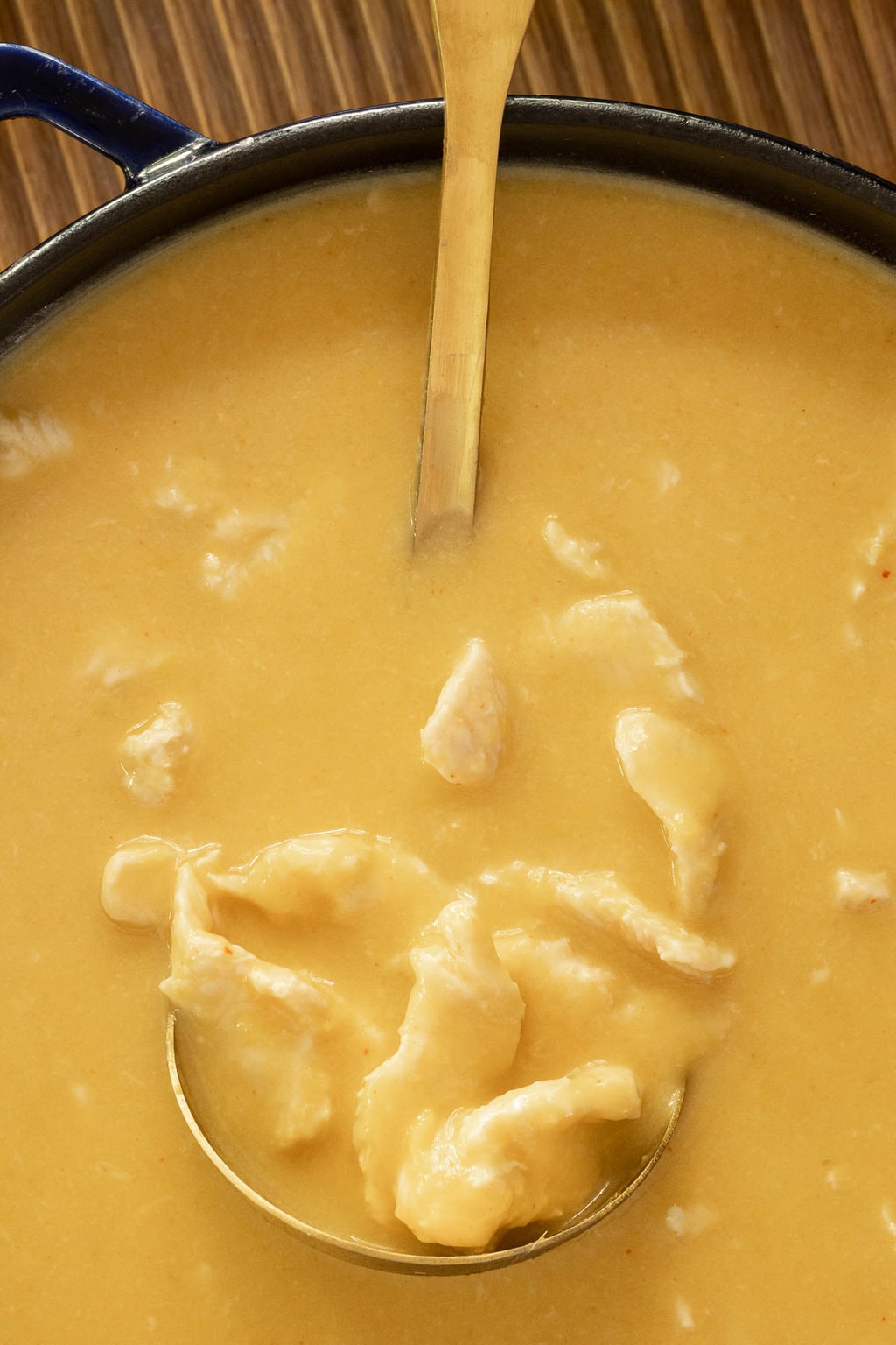 Vertical overhead closeup photo of a pot of Thai Coconut Chicken Soup.