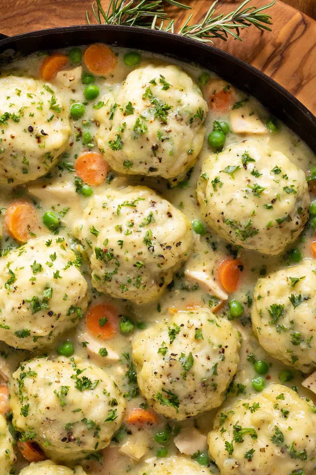 Vertical closeup overhead photo of a cast iron pot filled with Easy Chicken and Dumplings.