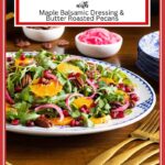 Vertical photo of a Cranberry Clementine Arugula Salad on a blue and white patterned serving platter with bowls of condiments in the background.