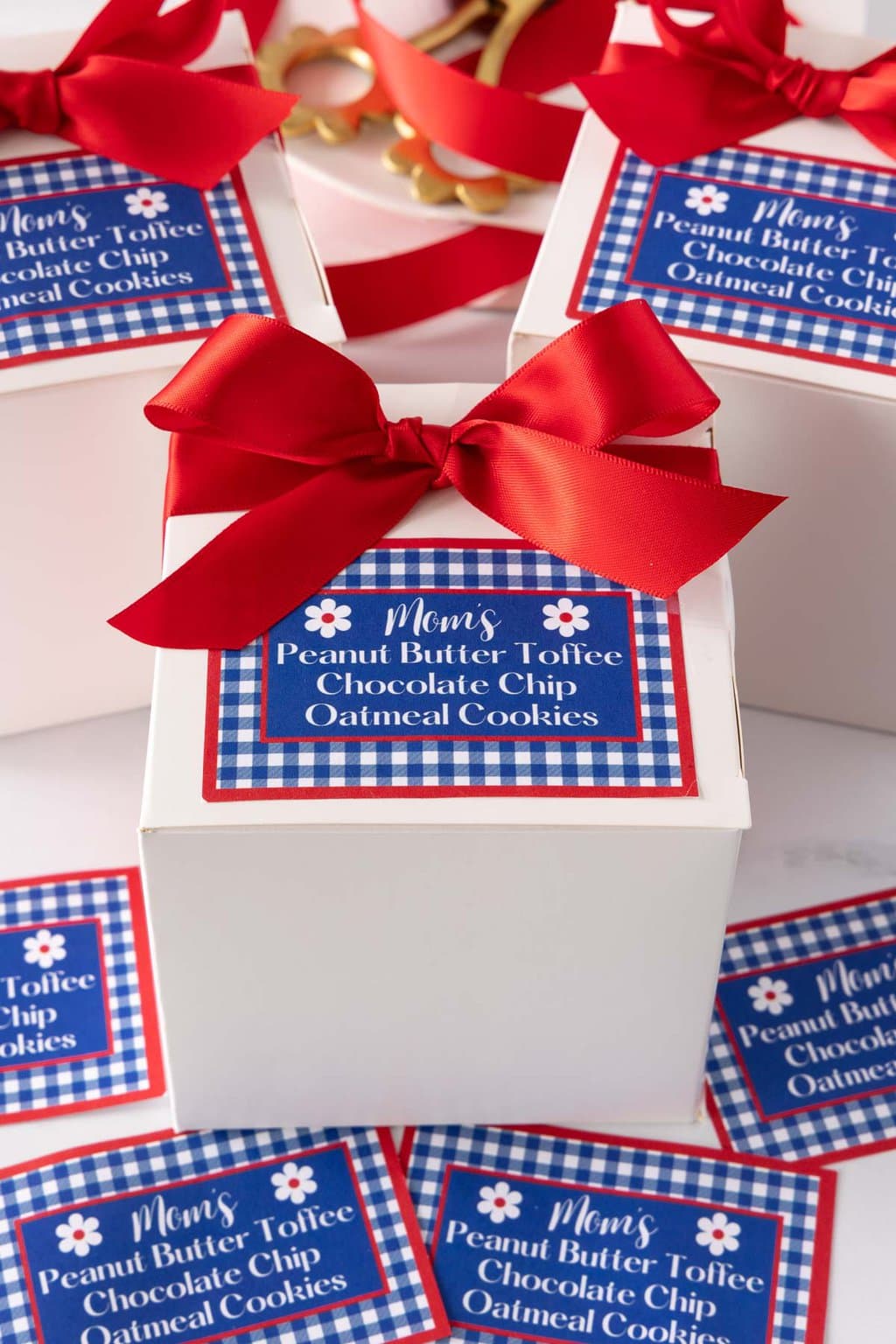 Vertical photo of Better than Crumbl Mom's Recipe Cookies in gift boxes with custom labels for gift giving.