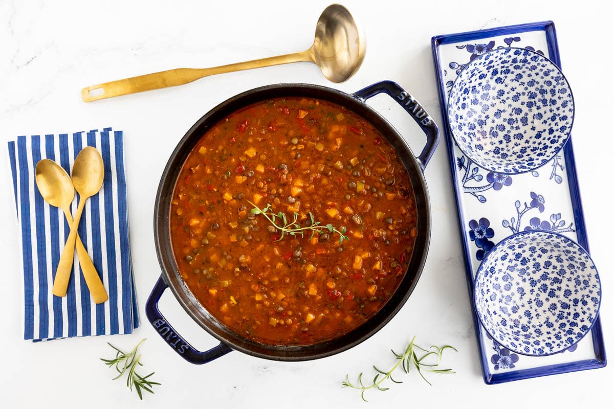 Horizontal overhead photo of a pot of French Lentil Soup on a marble table.