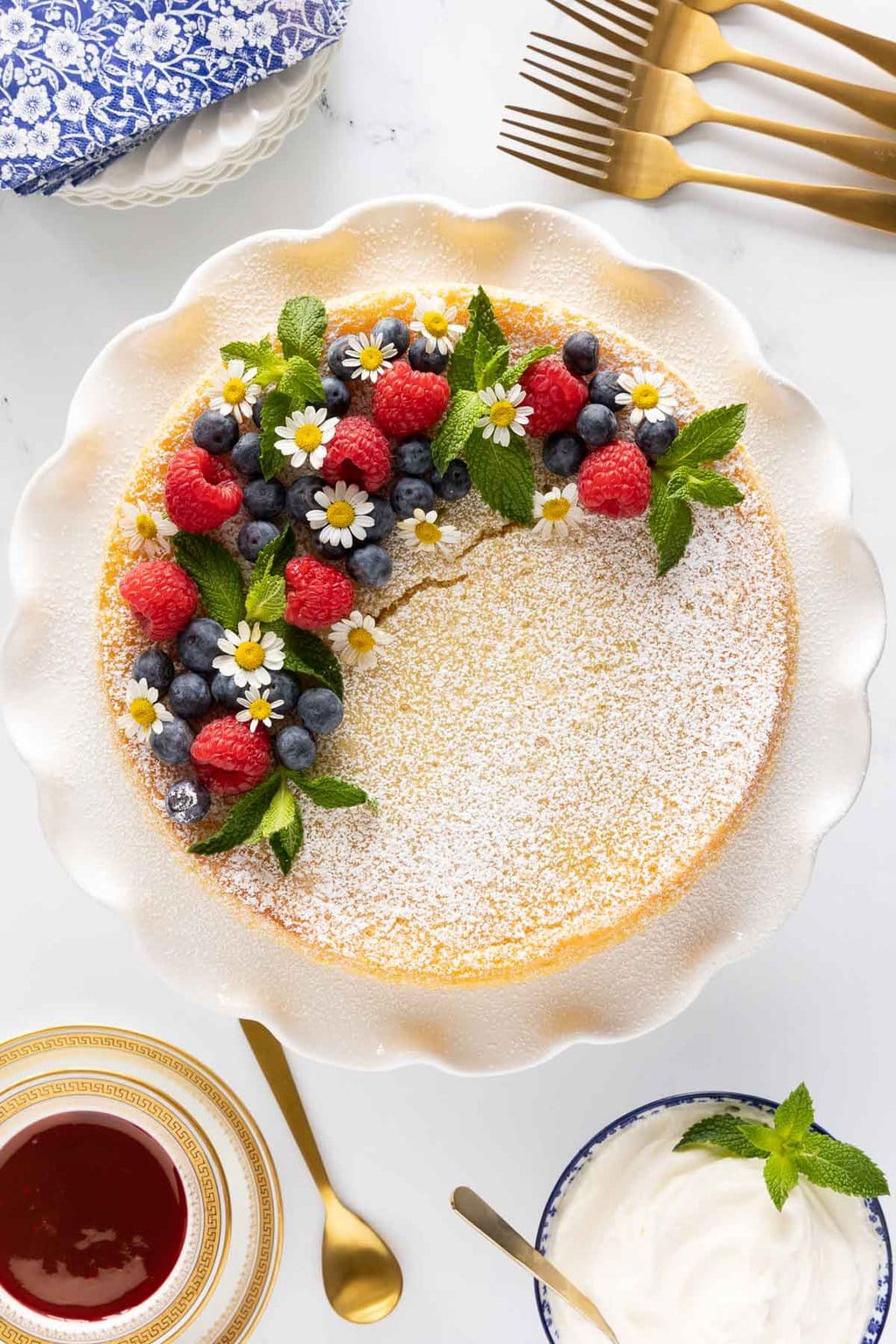 Vertical overhead photo of a Ridiculously Easy Crustless Lemon Tart decorated with fresh fruit, mint leaves and edible flowers.
