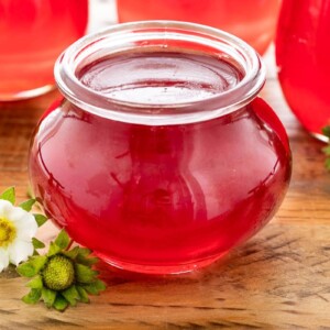 Horizontal closeup photo of a jar of Fresh Strawberry Jelly.