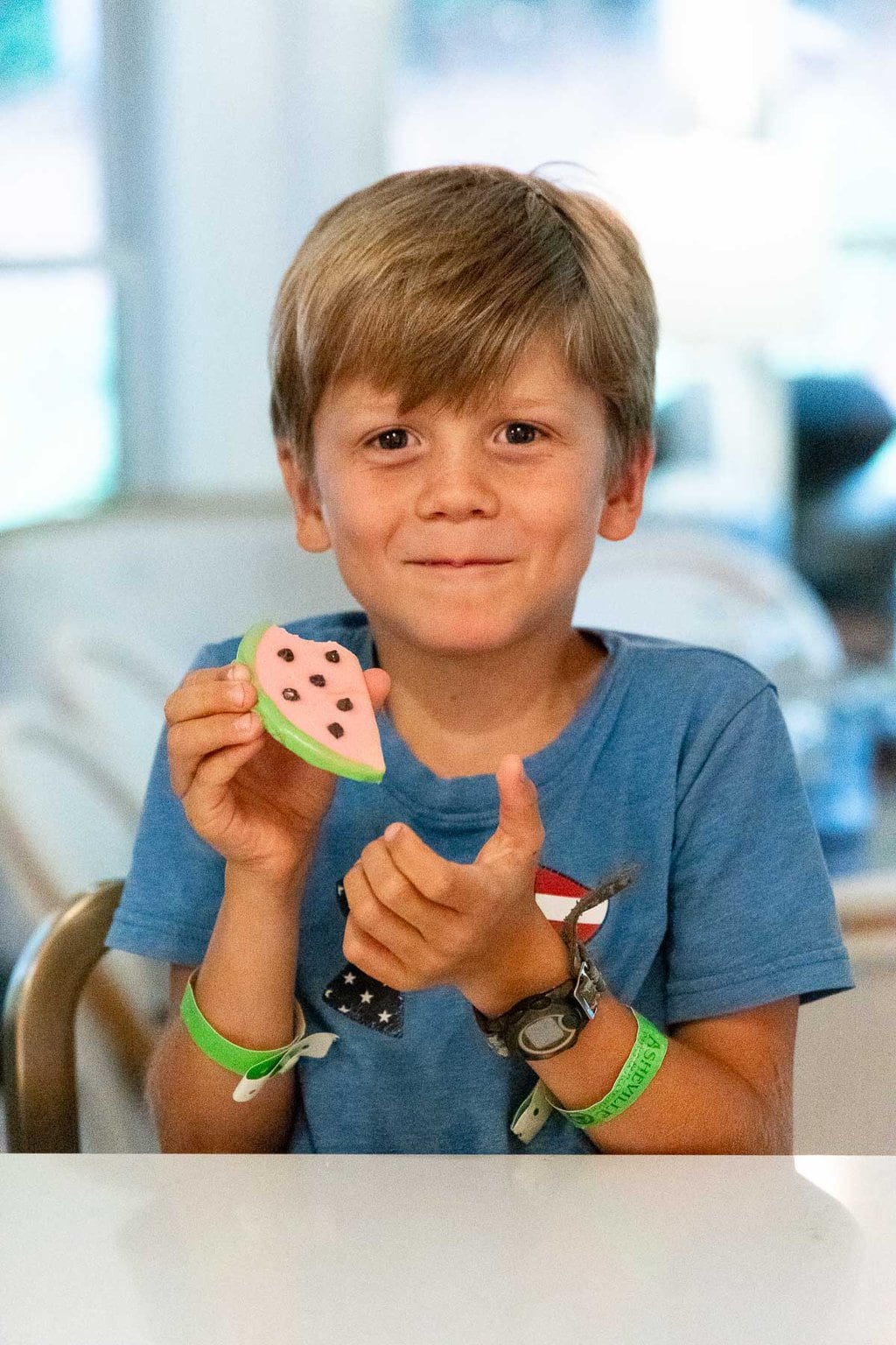 Vertical photo of Hayes displaying a Watermelon Shortbread Cookie he just created.