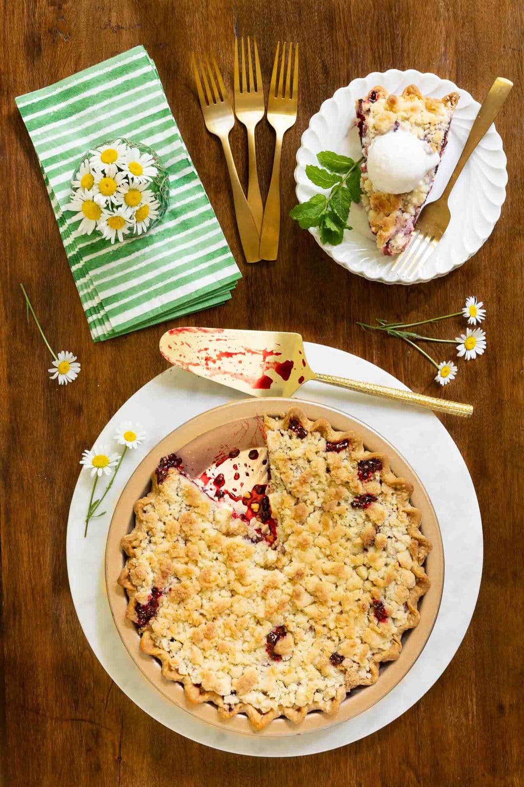Vertical overhead photo of a Easy Blackberry Crumble Pie with a slice cut out and ice cream on top.