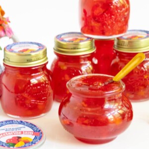 Horizontal photo of a batch of Fresh Nectarine Jam in canning jars with custom labels for gift giving.