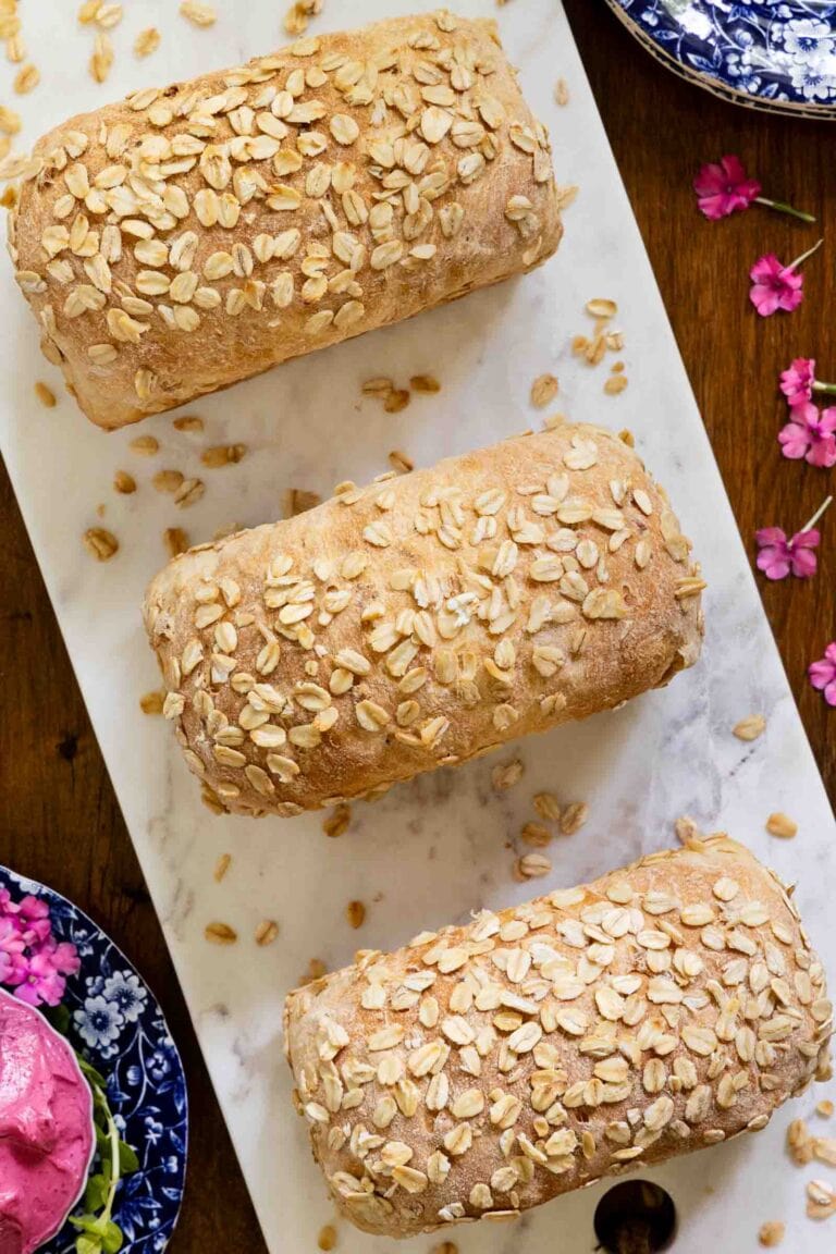 Mini loaves of porridge bread on a marble platter. 