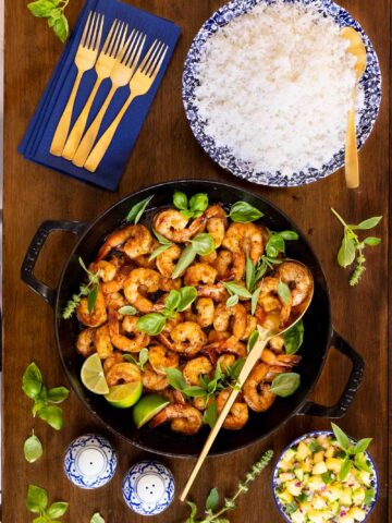 Vertical overhead photo of a skillet pan of Vietnamese Caramel Shrimp with rice and Pineapple Basil Salsa.