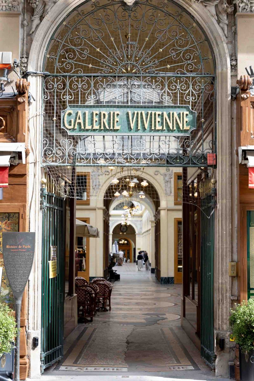 Vertical photo of Galerie Vivienne, one of the upscale gallery shopping/dining areas in Paris.
