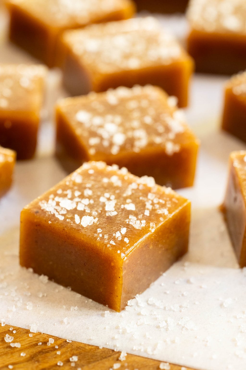 Vertical extreme closeup photo of a batch of Ridiculously Easy Sea-Salted Pumpkin Microwave Caramels.