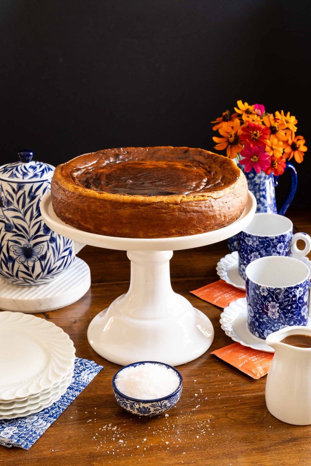 Vertical photo of a Ridiculously Easy Basque Sweet Potato Cheesecake on a white pedestal serving plate.