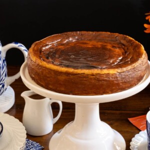 Horizontal photo of a Ridiculously Easy Basque Sweet Potato Cheesecake on a white pedestal serving plate.