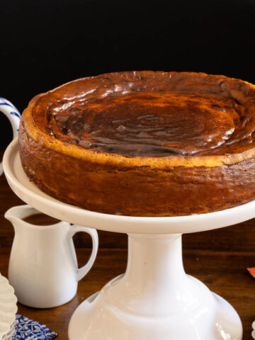 Horizontal photo of a Ridiculously Easy Basque Sweet Potato Cheesecake on a white pedestal serving plate.