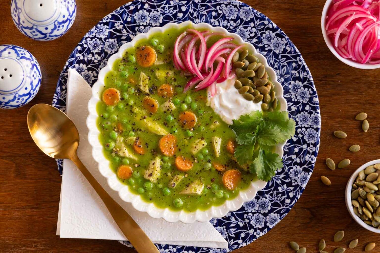Peruvian Chicken and Rice soup in a blue and white bowl with toppings.