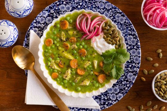 Peruvian Chicken and Rice soup in a blue and white bowl with toppings.