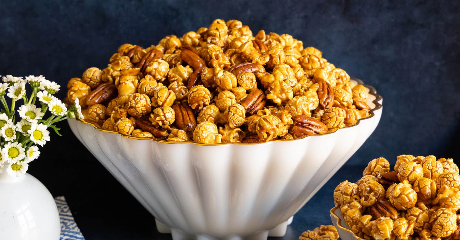 Horizontal photo of a white serving bowl of Ridiculously Easy Pecan Pie Caramel Corn.