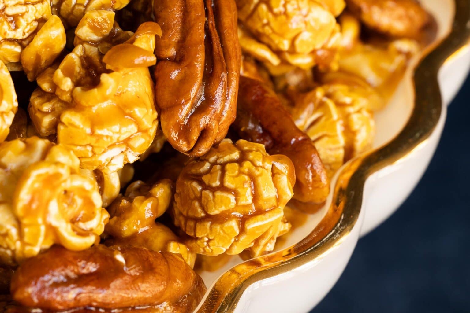 Horizontal extreme closeup photo of a batch of Ridiculously Easy Pecan Pie Caramel Corn.