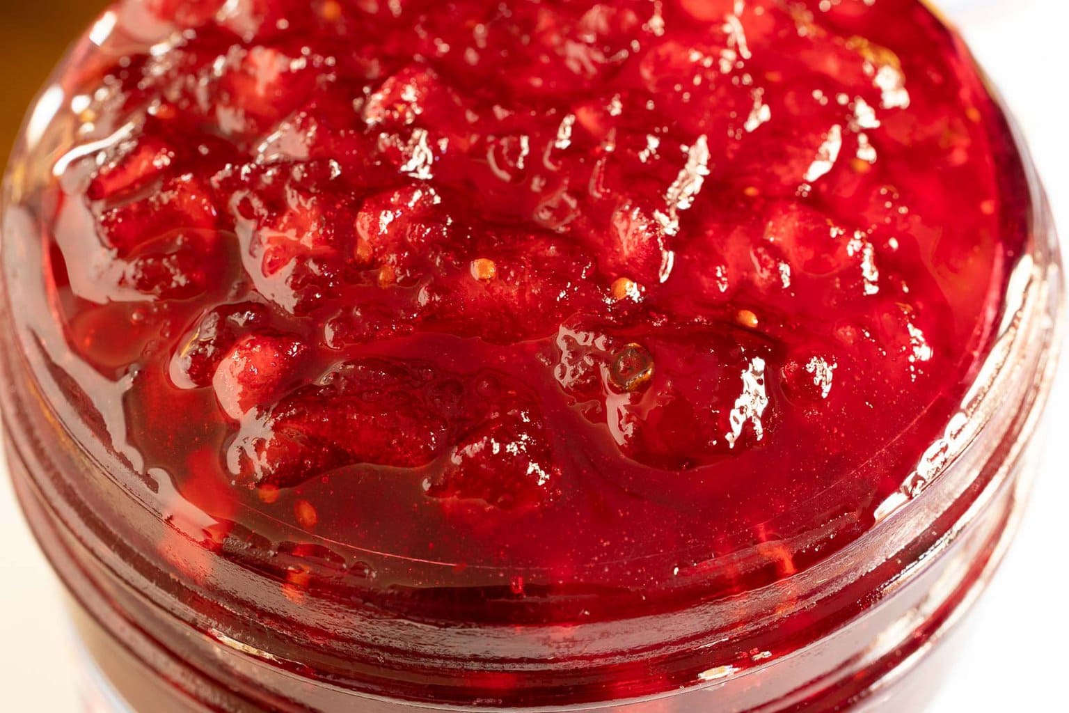 Horizontal extreme closeup photo of the top of a jar of Cranberry Apple Christmas Jam.