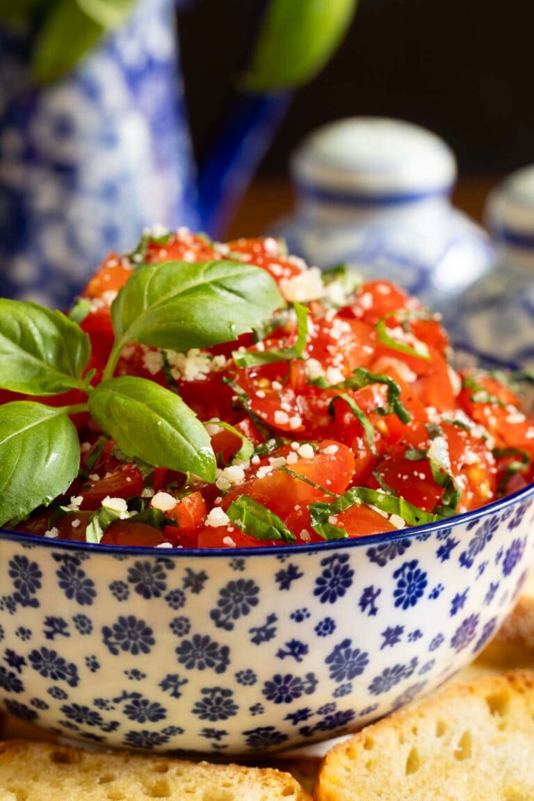 Italian Bruschetta in a blue and white bow with fresh basil.