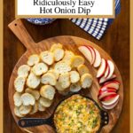 Vertical overhead photo of a wood appetizer board with Katherine's Fabulous, Ridiculously Easy Hot Onion Dip, crostini and apple slices.