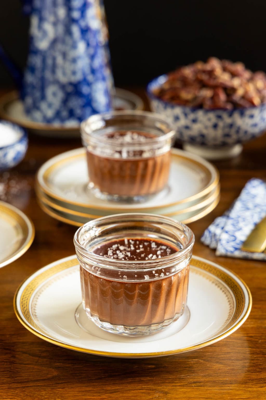 Vertical photo of a batch of Ridiculously Easy 5 Minute Chocolate Mousse desserts in glass serving cups sprinkled with sea salt.
