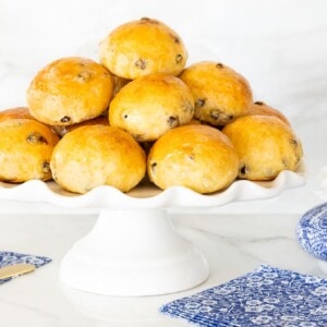 Horizontal photo of a batch of Irish Freckle Bread Rolls on a white pedestal serving plate.