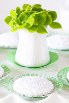 Horizontal photo of a batch of Key Lime Cooler Cookies on a white pedestal serving plate.