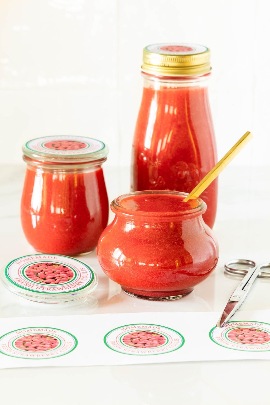 Vertical photo of jars of Ridiculously Easy Strawberry Coulis and custom labels for gift giving.