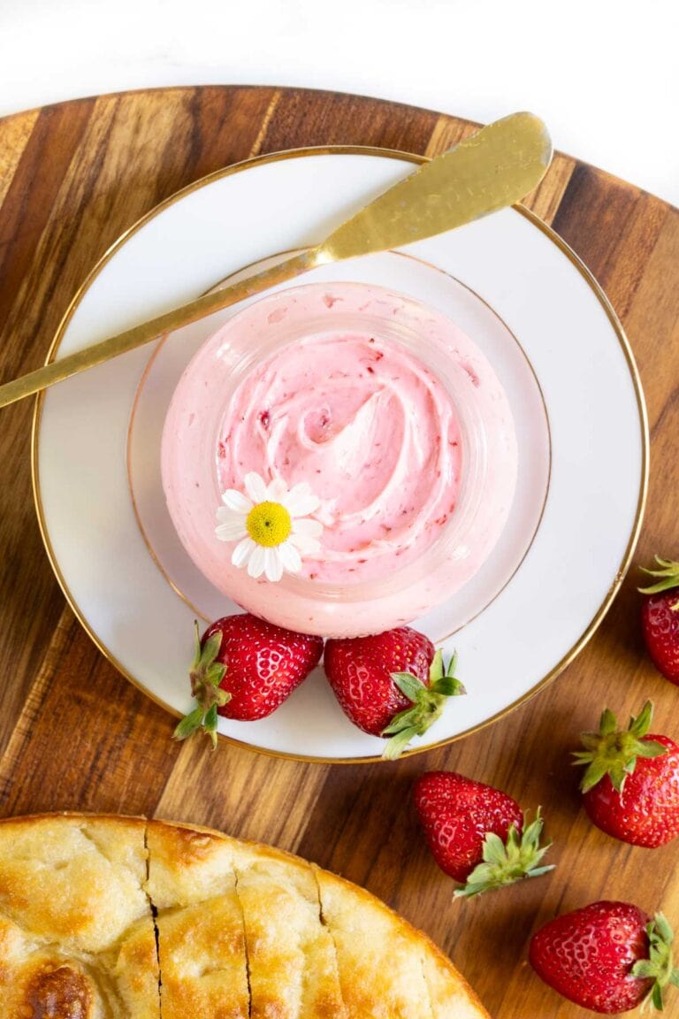 Strawberry butter in a glass jar with fresh bread and berries.