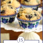 Vertical closeup photo of a batch of Better than Starbucks Blueberry Muffins on a white lattice pedestal serving plate.