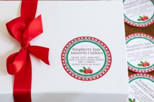 a white box of Raspberry Jam Amaretti Cookies tied with a red ribbon and a custom label affixed