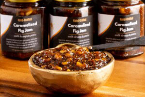 Caramelized fig jam in glass jars with printed labels.