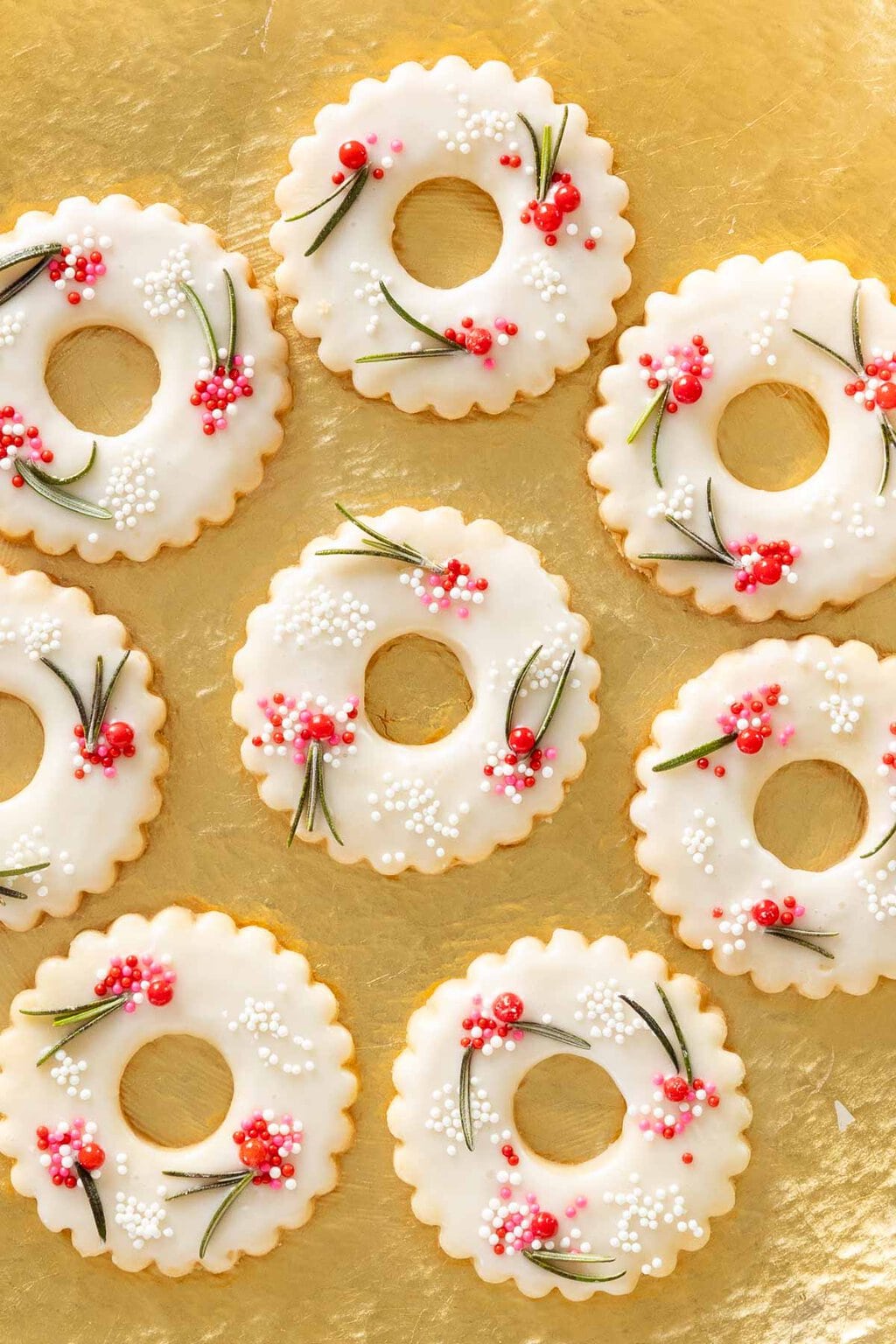 Vertical overhead photo of a batch of Berries on the Wreath Shortbread Cookies on a gilded serving plate.