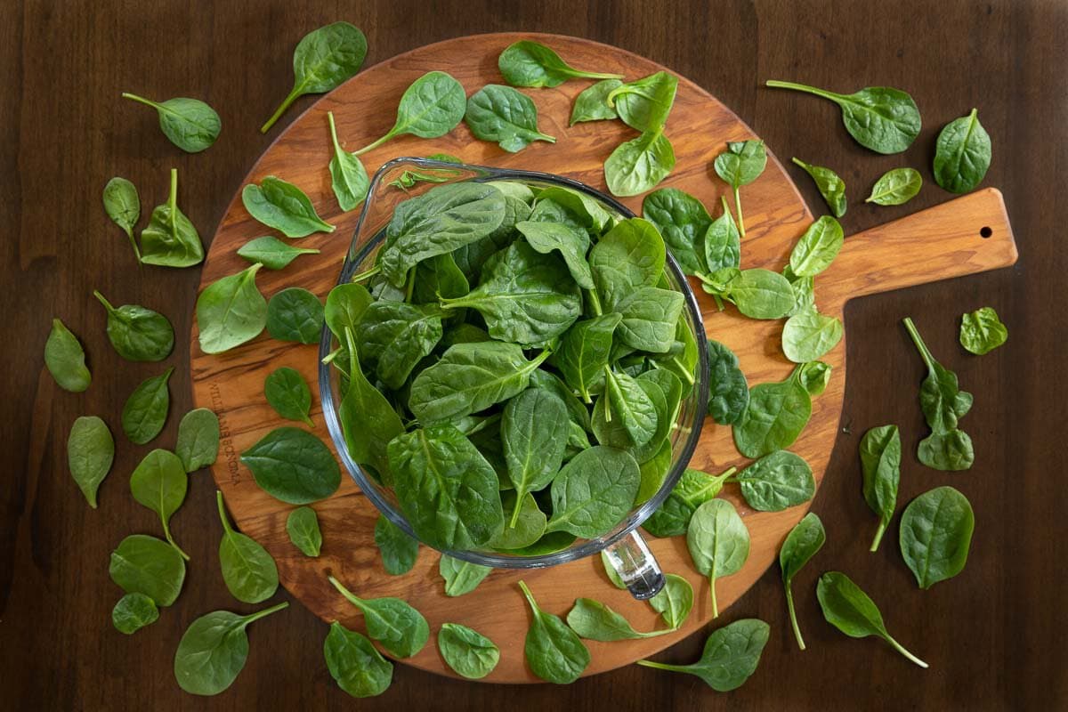 Horizontal overhead photo of the amount of spinach in a pot of Marry Me Chicken and Spinach Risotto before cooking it down.