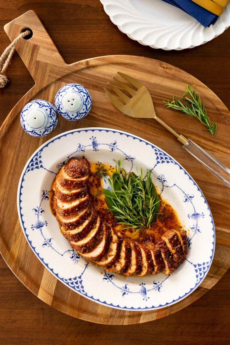 Oven Roasted Pork Tenderloin sliced on a white platter.