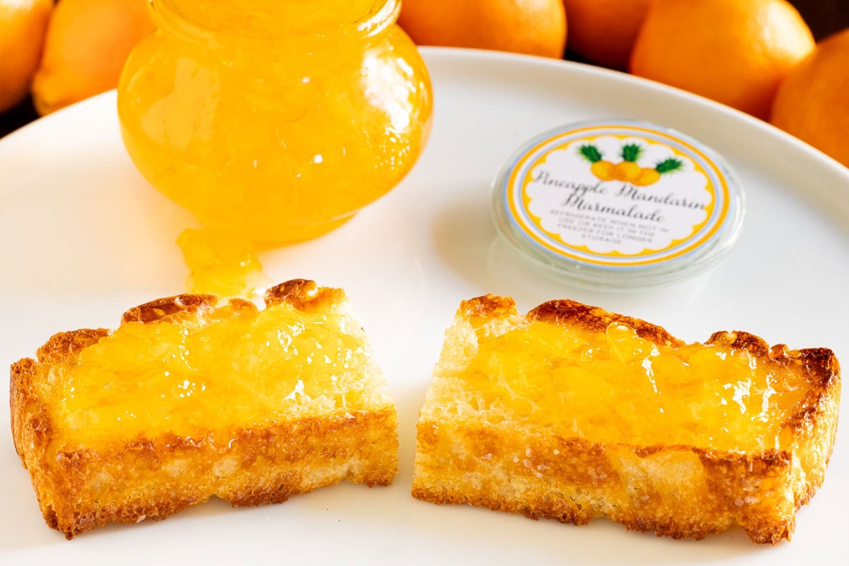 Pineapple Mandarin Marmalade - thecafesucrefarine.com Horizontal closeup photo of a toasted slice of Potato Focaccia bread spread with Pineapple Mandarin Marmalade.