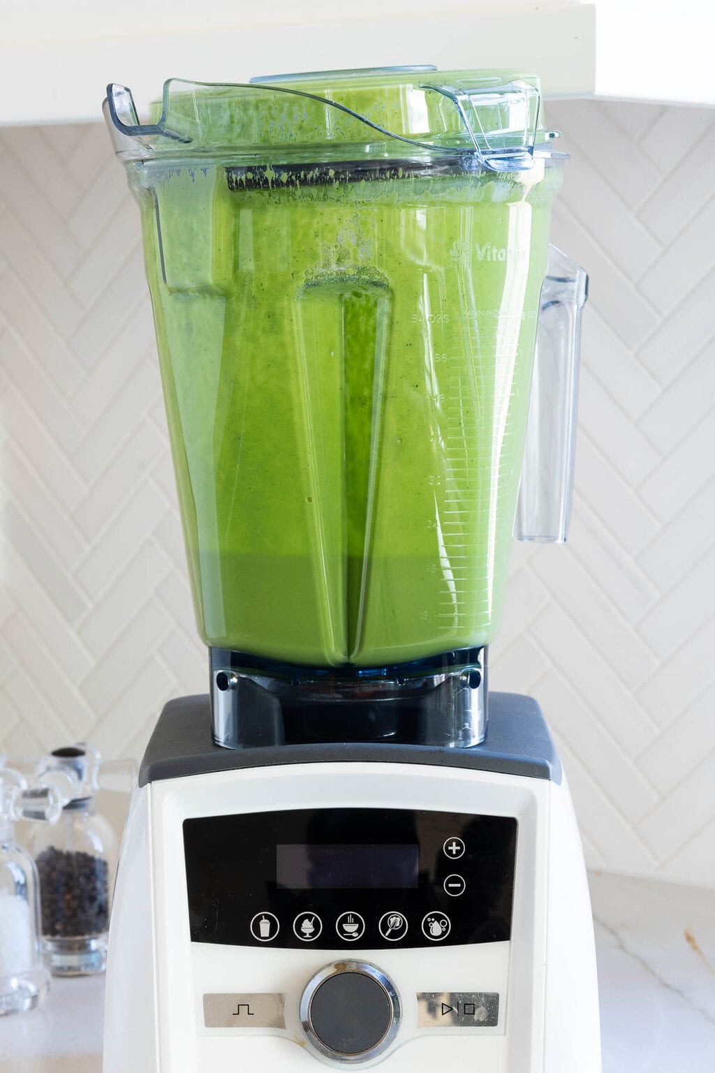 Green Goddess Dressing - thecafesucrefarine.com Vertical closeup photo of a Vitamix filled with blended herbs for making Green Goddess Dressing.