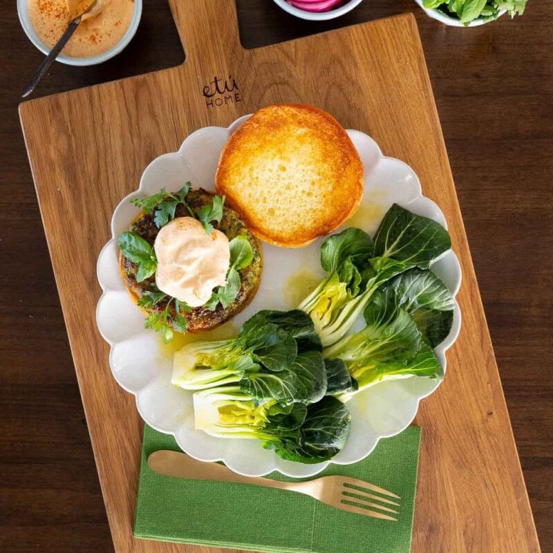Fresh Herb Chicken Burgers on a white plate with small bowls of toppings