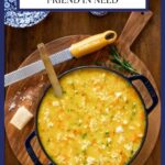 Pot of Italian Chicken Pastina Soup on a wooden cutting board with parmesan cheese.