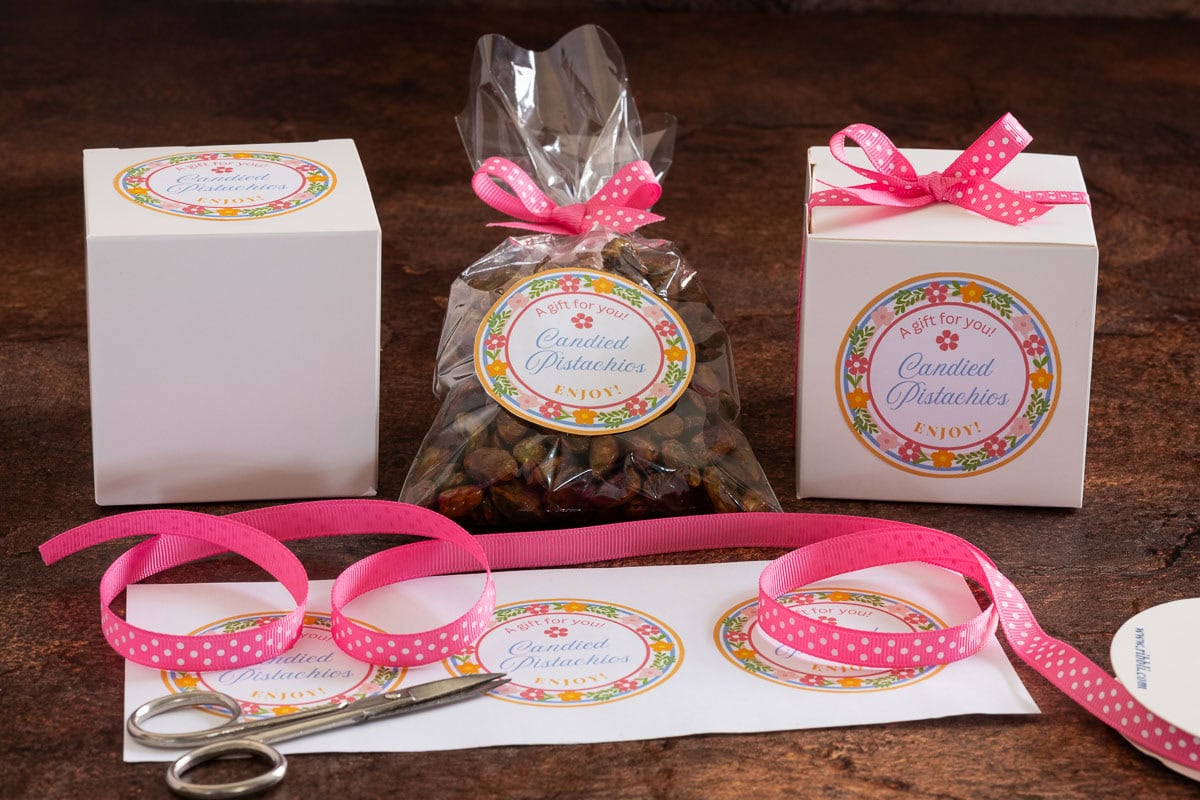 Horizontal photo of Ridiculously Easy Candied Pistachios in gift bags and boxes including custom gift labels.