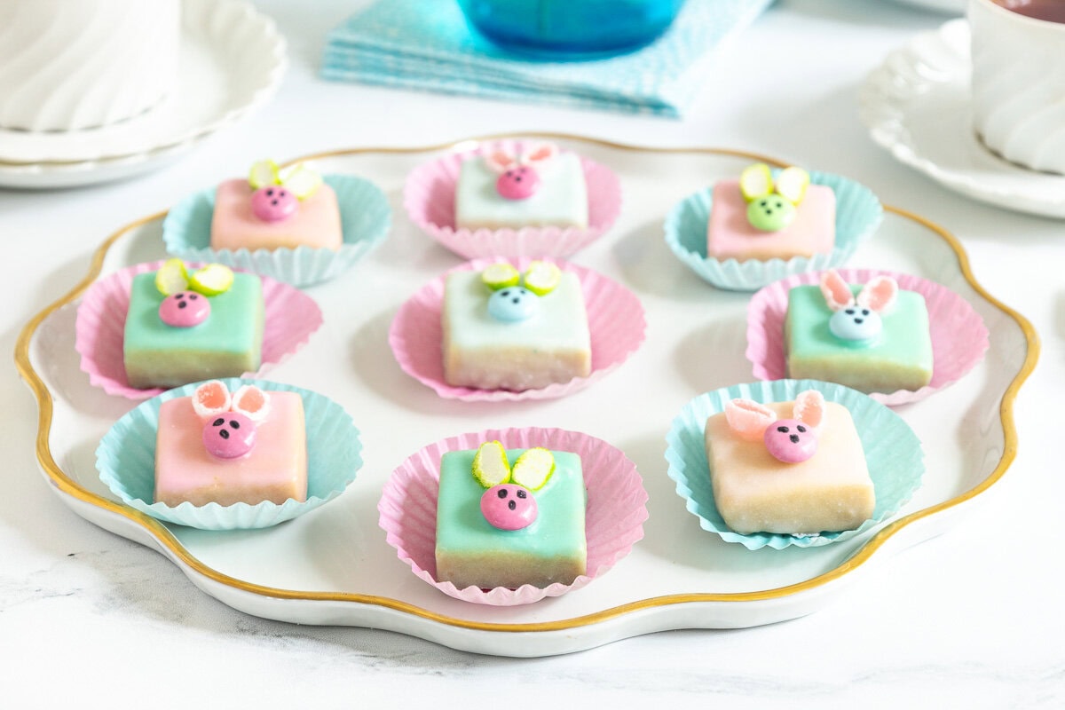 a plate of pastel colored easter bunny bites with cute little bunny faces on each one
