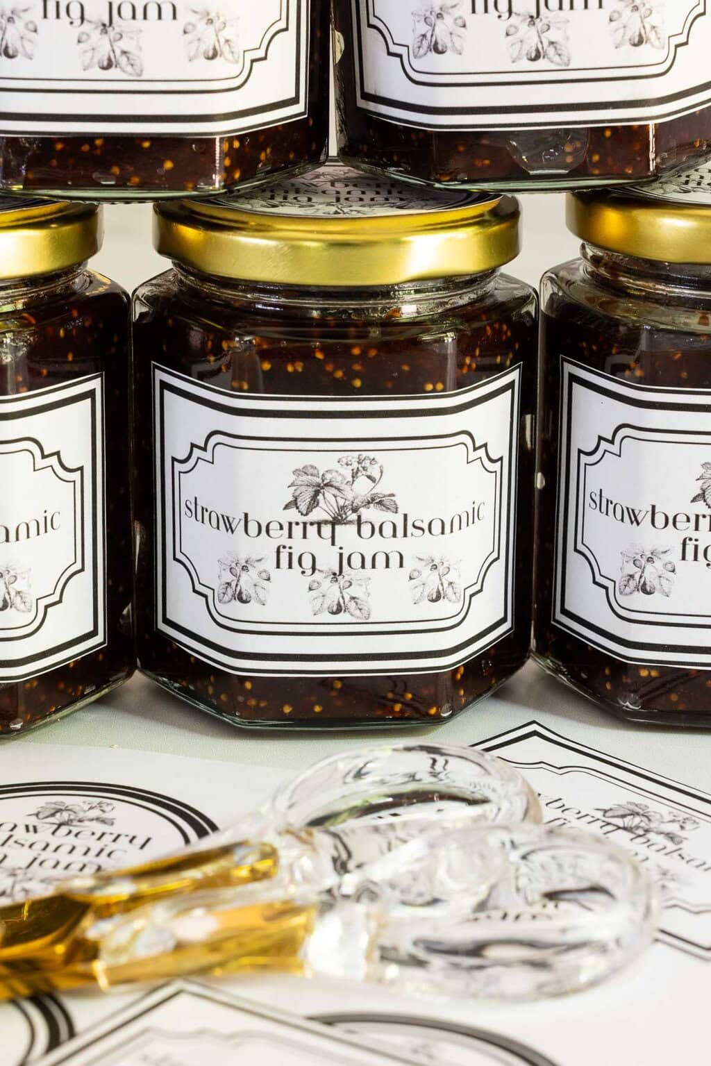 Close-up of of jars of strawberry balsamic fig jam with black and white labels.